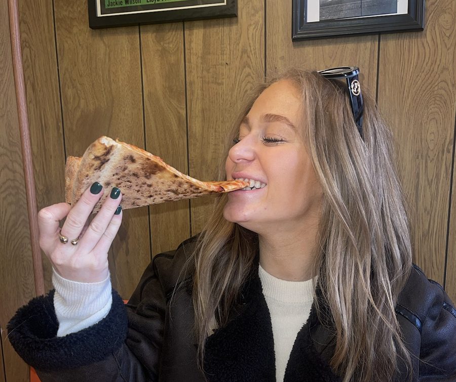 Ellie eating a slice of pizza